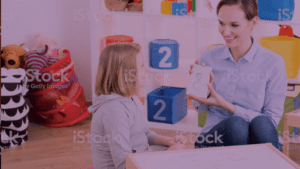 woman helping child with learning cards